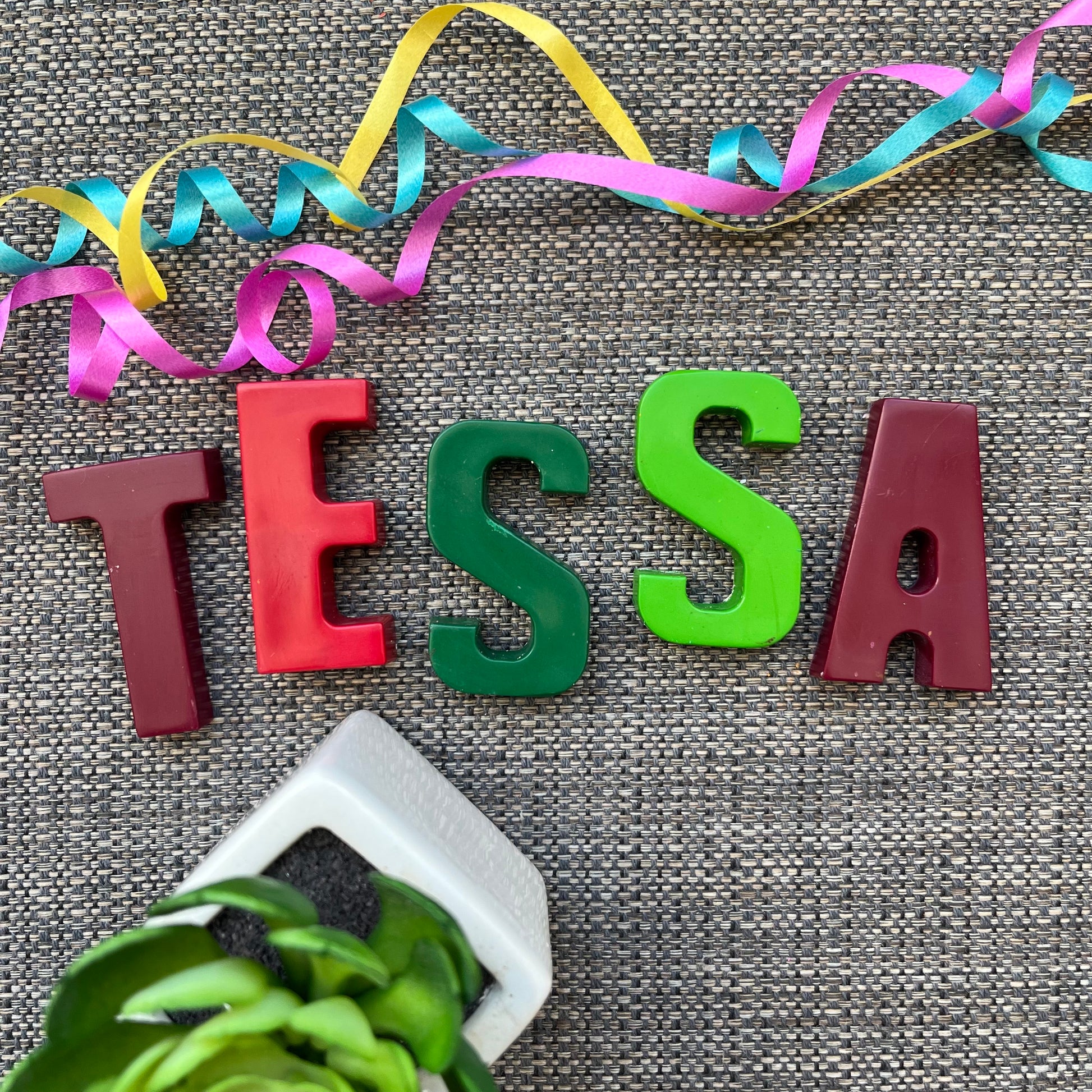 name TESSA is crayons. T is burgundy, E is red, S is dark green, S is light green and A is burgundy
